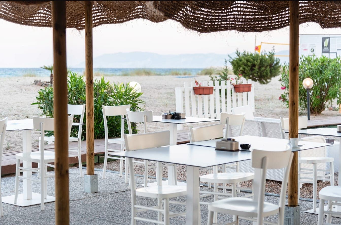 Dehor del Lungomare Bar Bistrot con tavoli bianchi vicino alla spiaggia