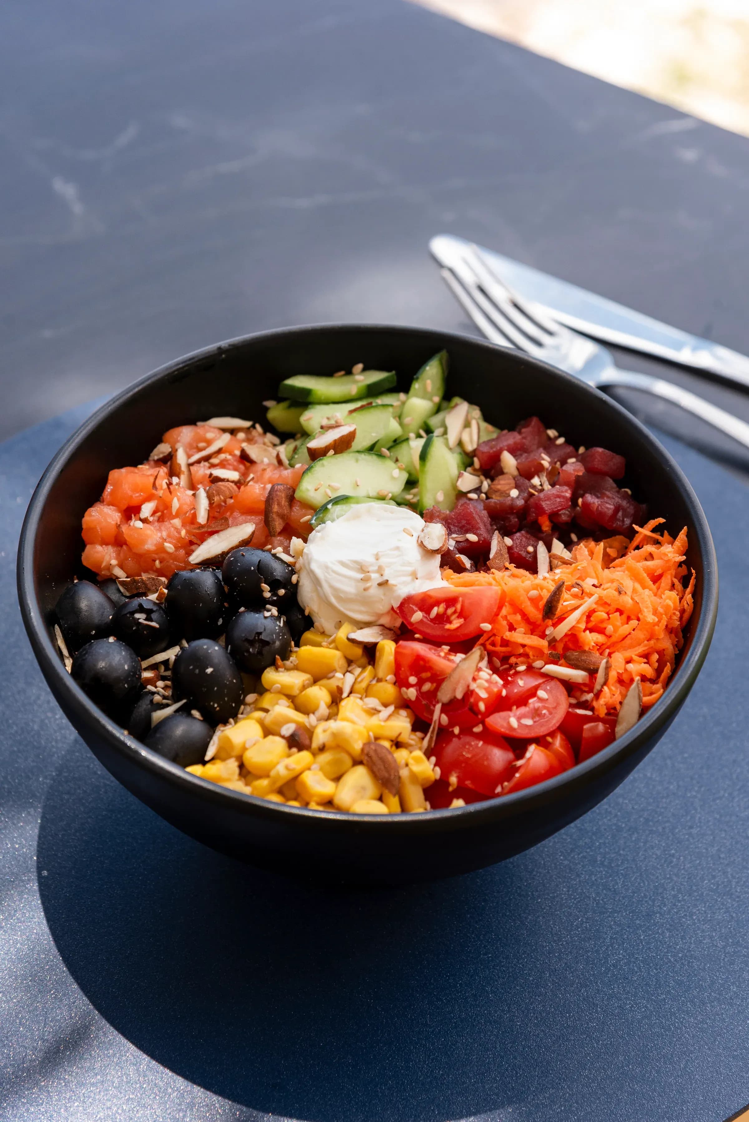 Poke bowl con salmone, verdure, olive, mais e formaggio fresco